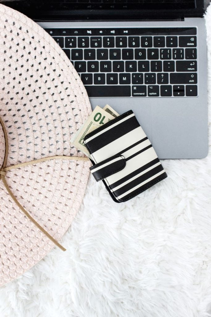 20 Tips For Beginner Bloggers: Grow It Faster And Better 8 A laptop, hat brim and wallet with money coming out of it.