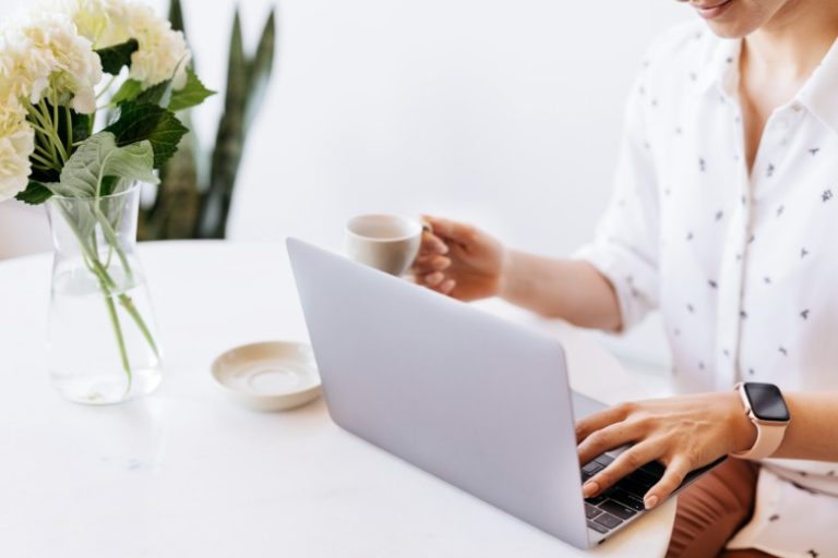 A woman typing on a keyboard: what is a cornerstone blog post and why do you need them on your blog