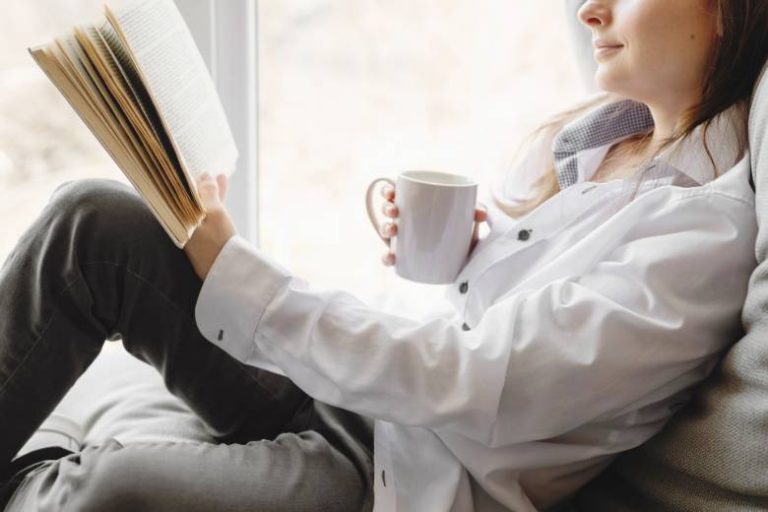 Faceless woman reading a book - motivational quotes for bloggers and small business owners.