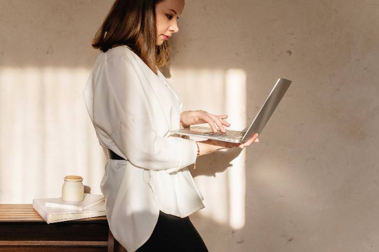 Woman lookin at a laptop while standing - does blogging make money.