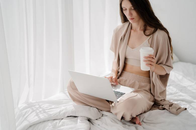 Facebook Group Etiquette: 5 Tips For Bloggers & Solopreneurs 3 Woman using a laptop on a bed - Facebook group etiquette for bloggers