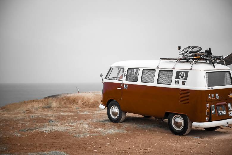 A vintage van with bikes overlooking the ocean - travel quotes for Instagram. 
