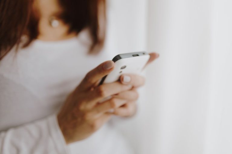 Faceless woman using a phone - how to spot a brand collaboration scam.
