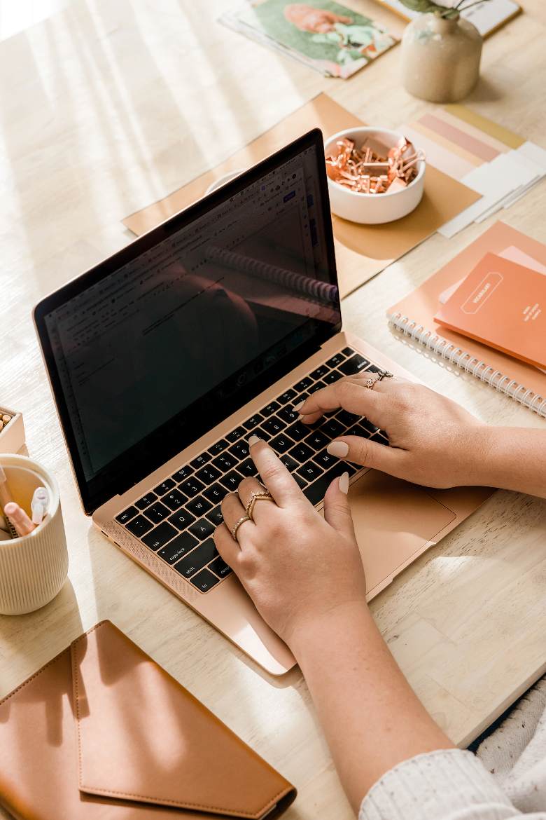 Woman typing on laptop.