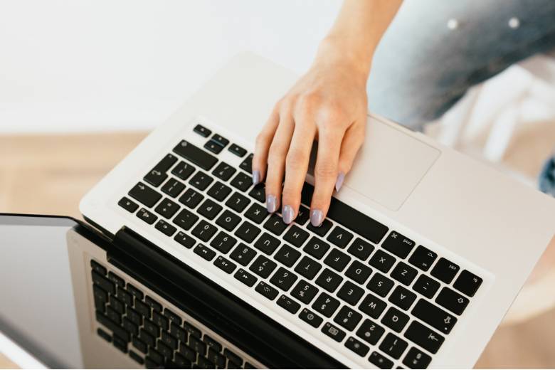 How To Make An Extra $100 Each Month Online To Fund Your New Blog 3 Faceless woman's hand using a laptop - how to make an extra $100 a month.