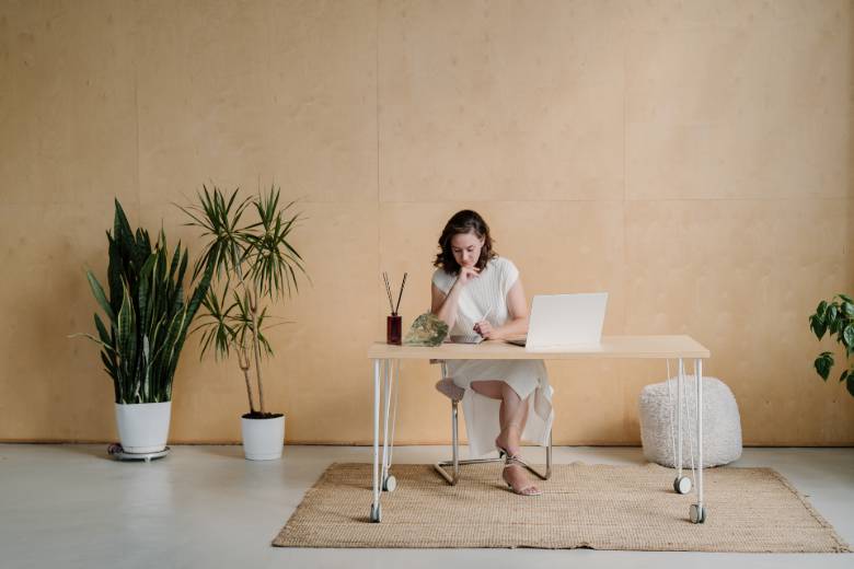 How To Turn A Blog Into A Business in 10 Steps 7 How to turn a blog into a business - changing your mindset - a woman sitting behind a desk with a laptop.