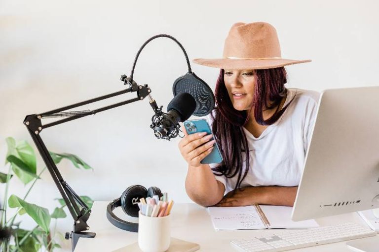 Woman reading from a phone using a microphone - why personal branding for bloggers.