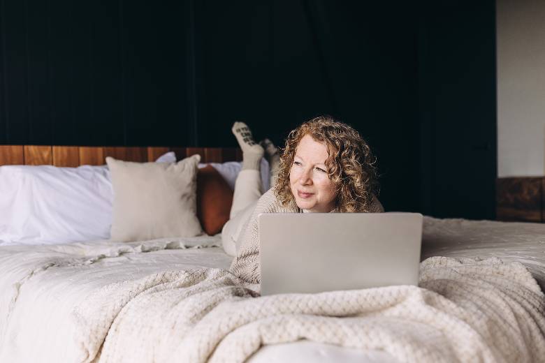 Woman on a bed with a laptop - how to start a lifestyle blog.