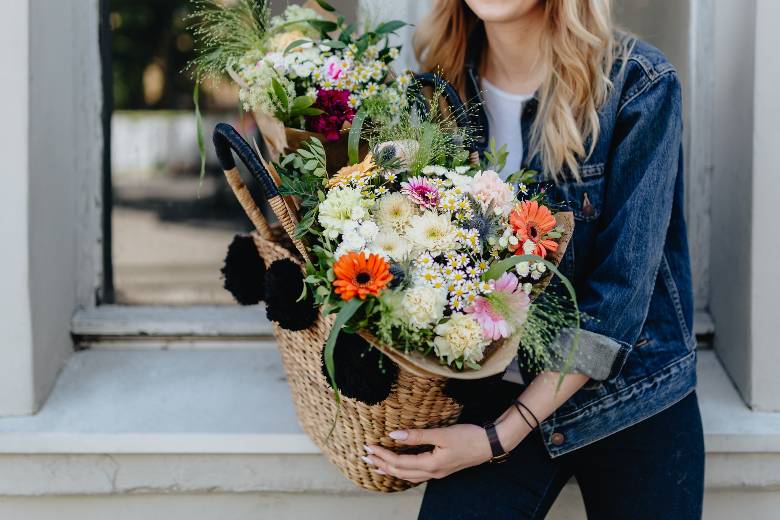 Woman carrying a basket of flowers - Spring quotes for Instagram