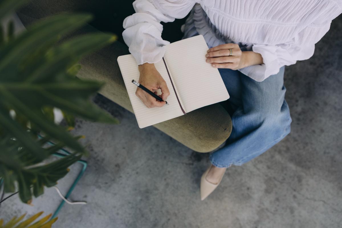 How I Write A blog Post Outline Using A Simple Framework Every Time 1 Faceless woman writing in a notebook - how to create a blog post outline with insights from blog coach Margaret Bourne.