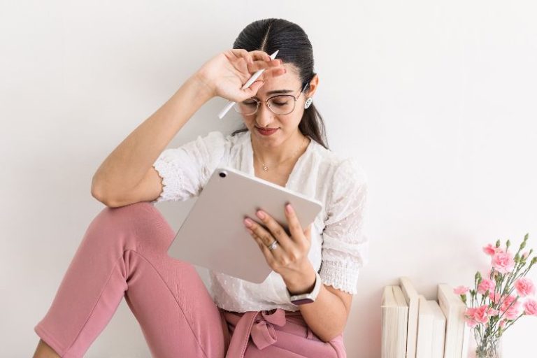 Young woman writing on a note page - how to find your blog audience.