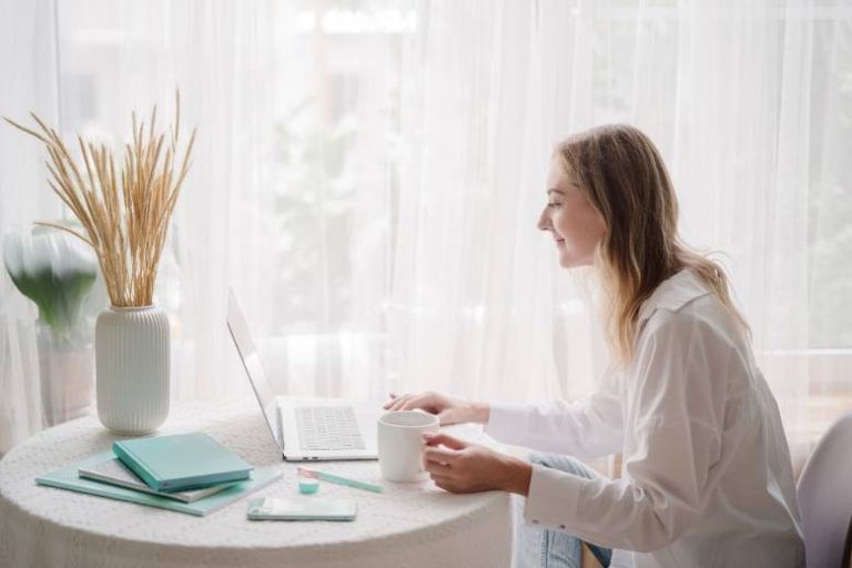 Woman sitting at a desk using a laptop - essential pages for blogs.