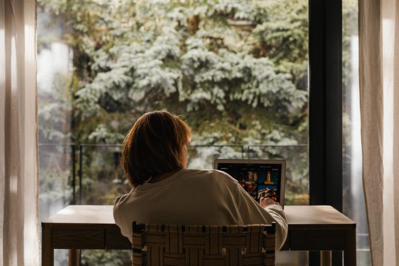 View of a woman from behind, using a laptop - how to update old blog posts.