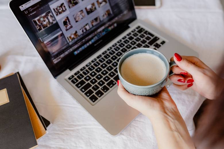 How to Write an SEO Title That Ranks & Gets More Clicks 1 Faceless person holding a coffee with a laptop - how to write an SEO title.