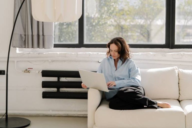 Woman on a sofa using laptop - setting up WordPress.