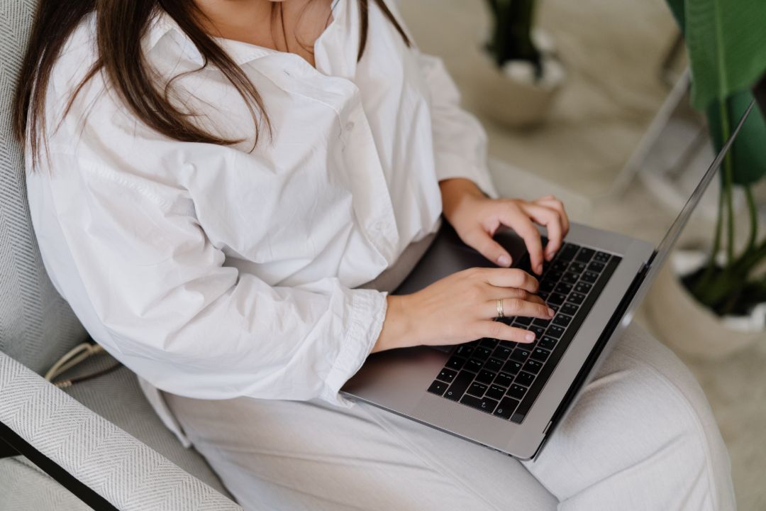 10+ Best Feminine Stock Photos For Bloggers & Business (2026) 1 Faceless woman using a laptop - best stock photo sites for bloggers and solo business owners with insights from MargaretBourne.com.