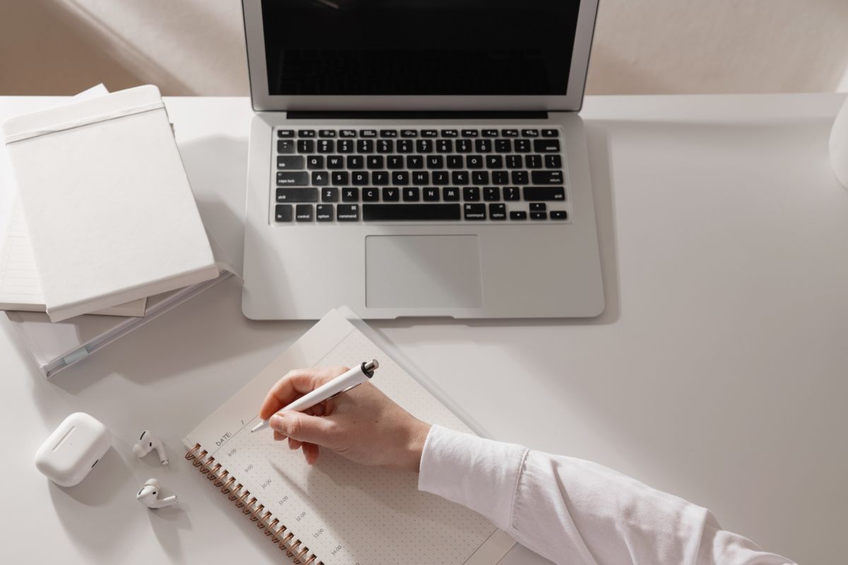 How To Create A Productive Blogging Schedule To Consistently Achieve Your Goals 8 Faceless person writing in a calendar - how to create a productive blogging routine.