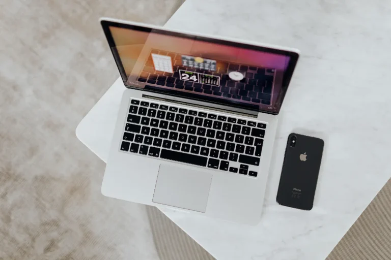 WordPress Setup and Maintenance Guide: What to Do After Installing WordPress 1 Laptop on a desk with a mobile phone - a WordPress setup and maintenance guide for bloggers from Margaret Bourne, blog coach.