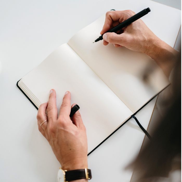 Services - Blog Coach 5 Faceless woman writing in a notebook - Social media and Pinterest audit — Margaret Bourne, blog coach.